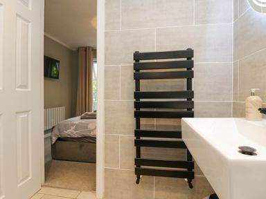 A bathroom with a sink and radiator at Badgers Hollow Lodge Grasmere 30, White Cross Bay near Windermere