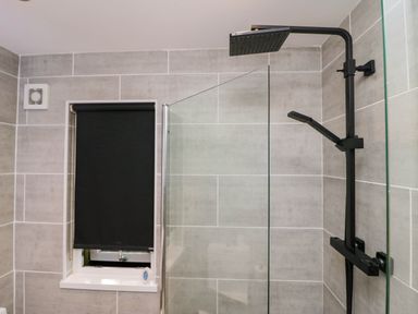 A bathroom with a shower and a window at Badgers Hollow Lodge in Grasmere 30, White Cross Bay near Windermere