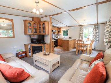 A living room with sofas and a coffee table connected to a kitchen and dining area at Pinehaven Lodge Grasmere 6 White Cross Bay near Windermere