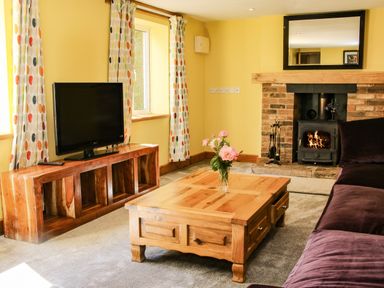 A living room with a wooden coffee table and fireplace at Sunnyside in Bircher Common near Yarpole