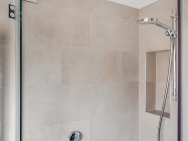 A tiled shower area with a wall niche and a chrome showerhead at Seascape in Salcombe