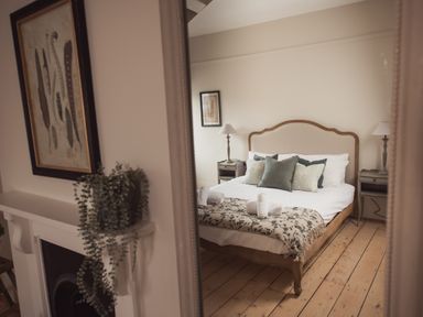 A bedroom with a bed and pillows visible in a mirror at Fairhaven in Dartmouth