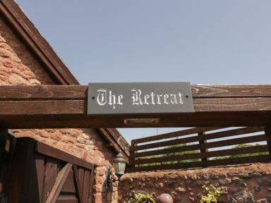 An outdoor wooden gate with a sign reading The Retreat at The Retreat in Washford near Williton