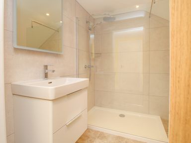 A bathroom with a sink and a walk in shower at The Stables Burton Bradstock