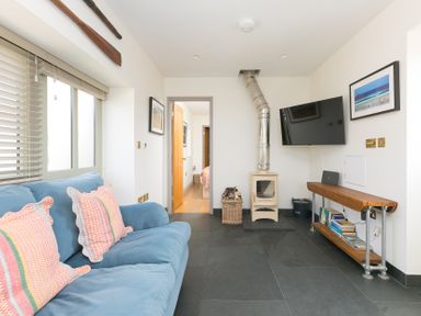 A living room with a sofa and television at Scilly Stack in St Just