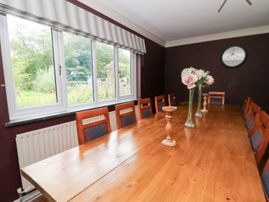 A dining room with a table and chairs at Tynewydd Fields in Cross Inn