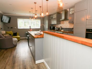 A kitchen with bar counter and seating at Tynewydd Fields in Cross Inn