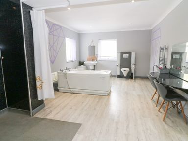 A bathroom with a bathtub, shower, toilet and sink at Tynewydd Fields in Cross Inn