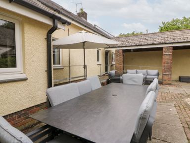 An outdoor dining area with a table and chairs at Tynewydd Fields in Cross Inn
