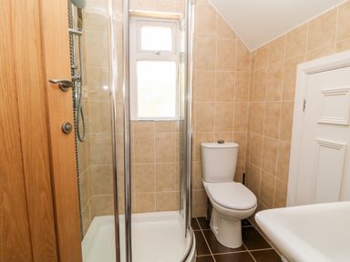 A bathroom with a shower enclosure a toilet and a sink at Harbour Lights in Torquay