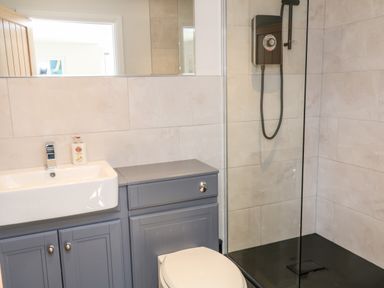 A bathroom with a sink a cabinet a toilet and a glass enclosed shower at Harbour Lights in Torquay
