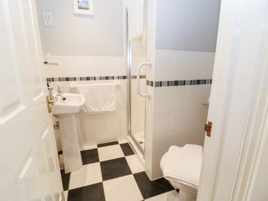 A bathroom with a pedestal sink towel rack shower and toilet at Farm View Lodge in Painswick