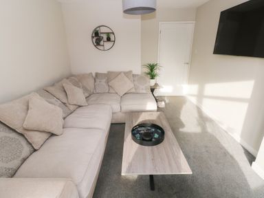 A living room with a sofa and coffee table at Westwinds in Tenby