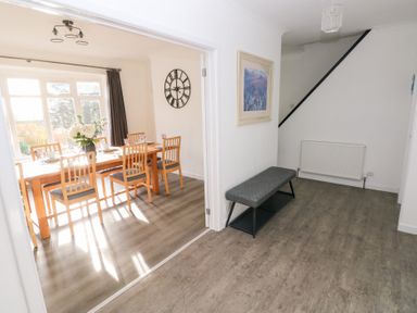 A hallway with a bench and view into the dining room at Westwinds, Tenby