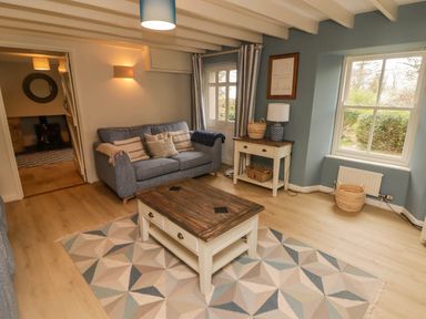 A living room with a sofa wooden coffee table and side table with lamp at Sea View in Newport Pembrokeshire