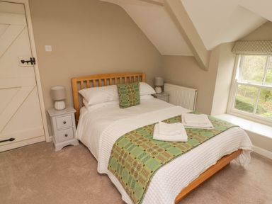 A bedroom with a bed bedside tables lamps and a window at Sea View in Newport Pembrokeshire