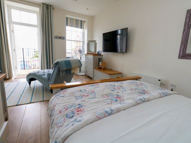 A bedroom with a bed and television at 4 The Beaches in Weymouth
