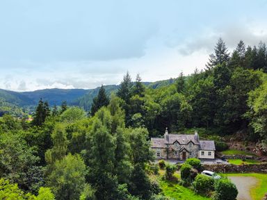 A house surrounded by trees and mountains at Greffyn in Betws-Y-Coed