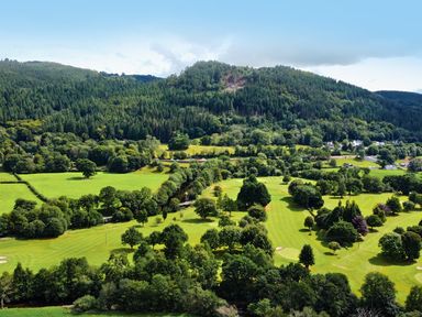 A landscape view of a golf course surrounded by trees at Greffyn in Betws-Y-Coed