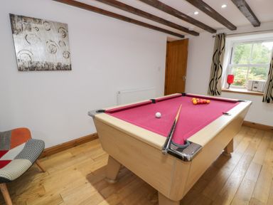 A game room with a pool table and a chair at Greffyn in Betws-Y-Coed