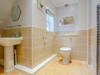 A bathroom with a pedestal sink mirror toilet and window at Jasmine Cottage Mickleton Gloucestershire