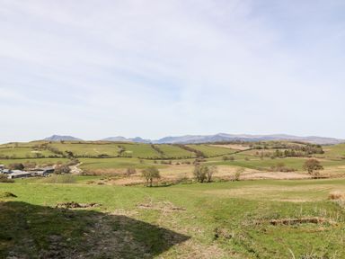 A rural landscape with fields trees and distant hills at Orsedd Wen Farmhouse in Betws-Y-Coed