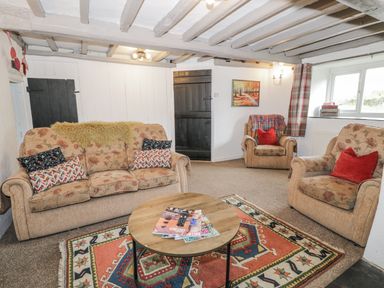 A living room with a sofa and armchairs at Orsedd Wen Farmhouse in Betws-Y-Coed
