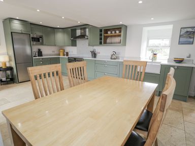 A kitchen with a dining table and chairs at Orsedd Wen Farmhouse in Betws-Y-Coed