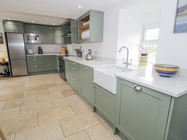A kitchen with cabinets and appliances at Orsedd Wen Farmhouse in Betws-Y-Coed