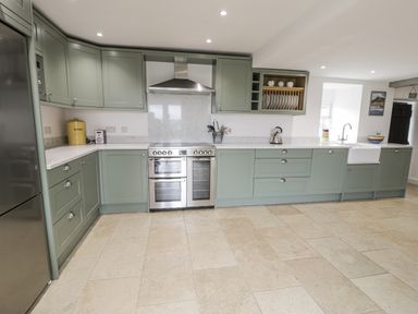 A kitchen with cabinets and appliances at Orsedd Wen Farmhouse in Betws-Y-Coed