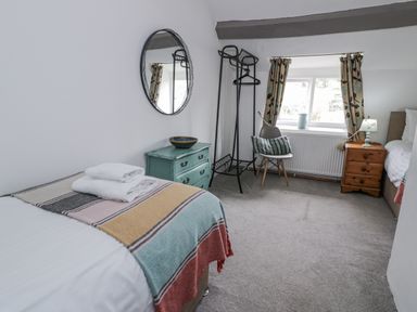 A bedroom with a bed and chair at Orsedd Wen Farmhouse in Betws-Y-Coed