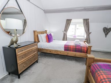 A bedroom with two beds and a dresser at Orsedd Wen Farmhouse Betws-Y-Coed