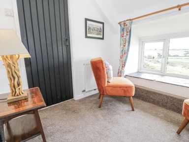 A snug with chairs and a lamp at Orsedd Wen Farmhouse in Betws-Y-Coed