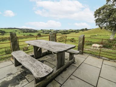 An outdoor area with a stone table and benches at Orsedd Wen Farmhouse in Betws-Y-Coed