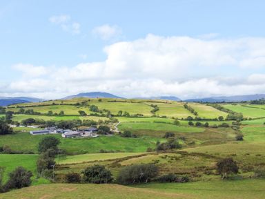 A landscape with fields and farm buildings at Orsedd Wen Farmhouse in Betws-Y-Coed