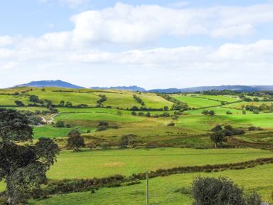 A view of green fields and hills at Orsedd Wen Farmhouse in Betws-Y-Coed