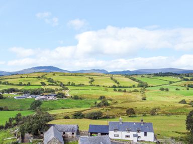 A landscape view with fields and houses at Orsedd Wen Farmhouse in Betws-Y-Coed