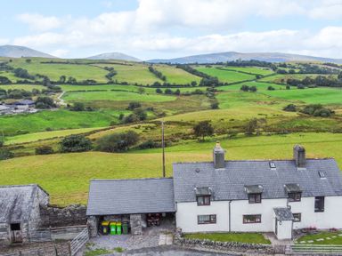 A farmhouse and green fields at Orsedd Wen Farmhouse in Betws-Y-Coed
