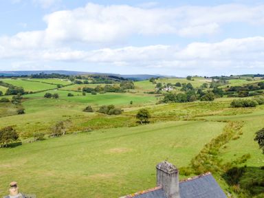 A landscape view with hills and trees at Orsedd Wen Farmhouse in Betws-Y-Coed