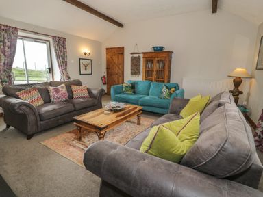 A living room with sofas and a coffee table at Orsedd Wen Cottage in Betws-Y-Coed