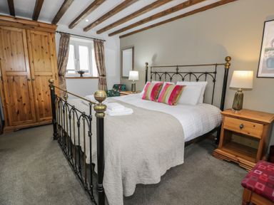 A bedroom with a bed and wardrobe at Orsedd Wen Cottage in Betws-Y-Coed