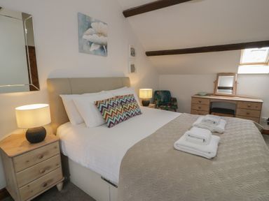 A bedroom with a bed and lamp at Orsedd Wen Cottage in Betws-Y-Coed