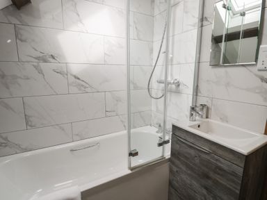 A bathroom with a bathtub and shower at Orsedd Wen Cottage in Betws-Y-Coed