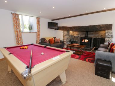 A snug with a pool table and fireplace at Cwm in Capel Curig