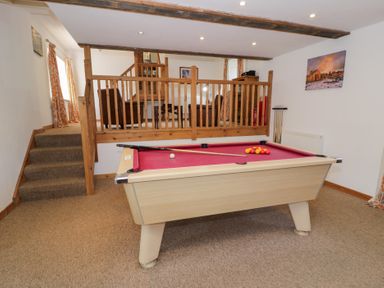 A game room with a pool table and stairs at Cwm in Capel Curig