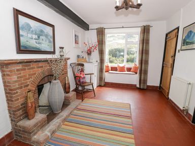 A living room with a fireplace and chair at Cwm in Capel Curig