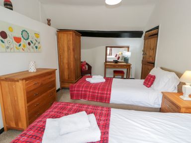 A bedroom with twin beds and wooden furniture at Cwm in Capel Curig