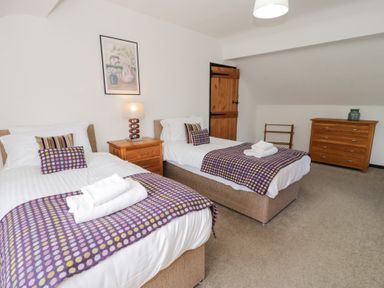 A bedroom with two beds and a chest of drawers at Cwm in Capel Curig