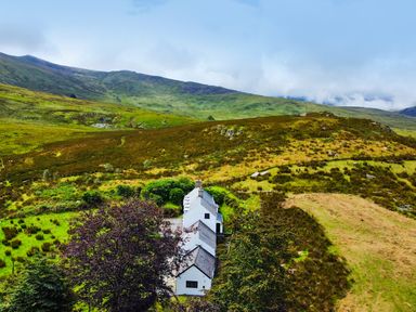 A house surrounded by trees and hills at Cwm in Capel Curig