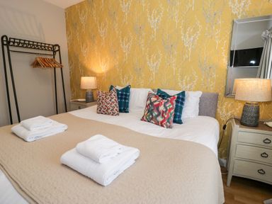 A bedroom with a bed and side table at Pengwern Bach in Llanrwst